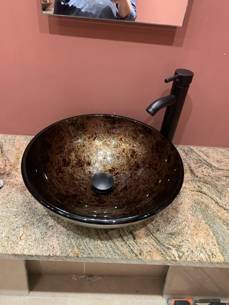 Glass vessel basin and black tap fitted by RRG Plumbing